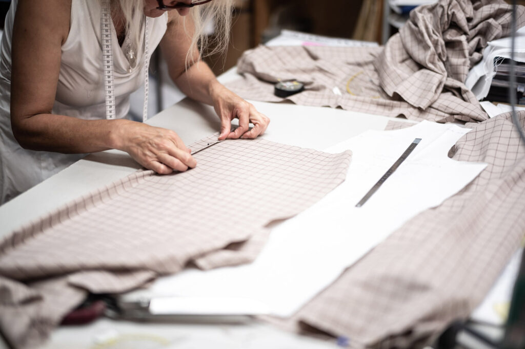 Hände beim Schneidern eines Maßhemdes