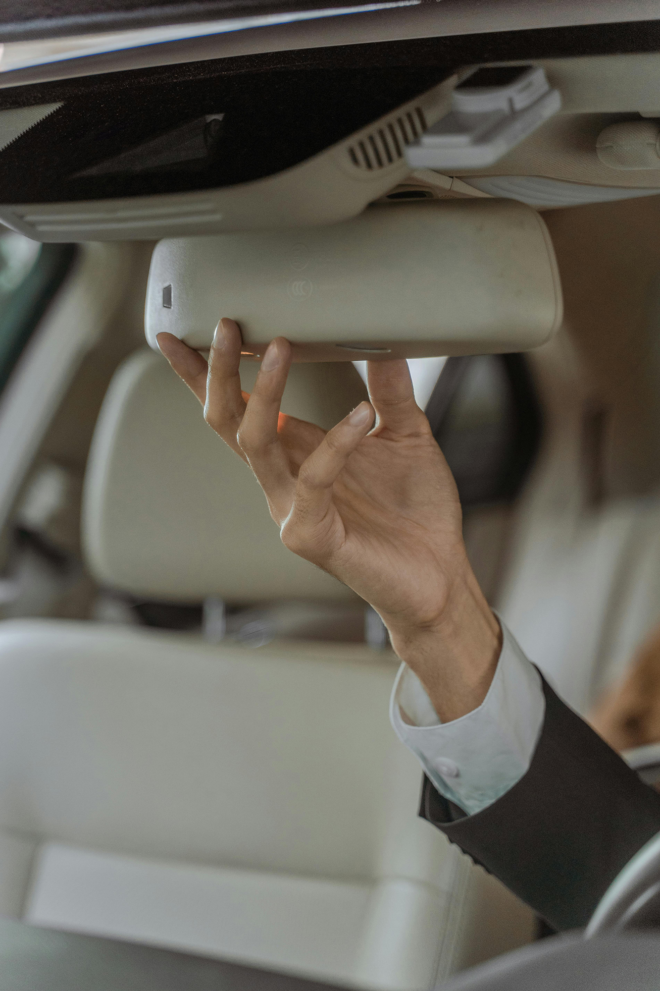 Hand eines Fahrers beim Einstellen der Devices im Fahrzeuginnenraum